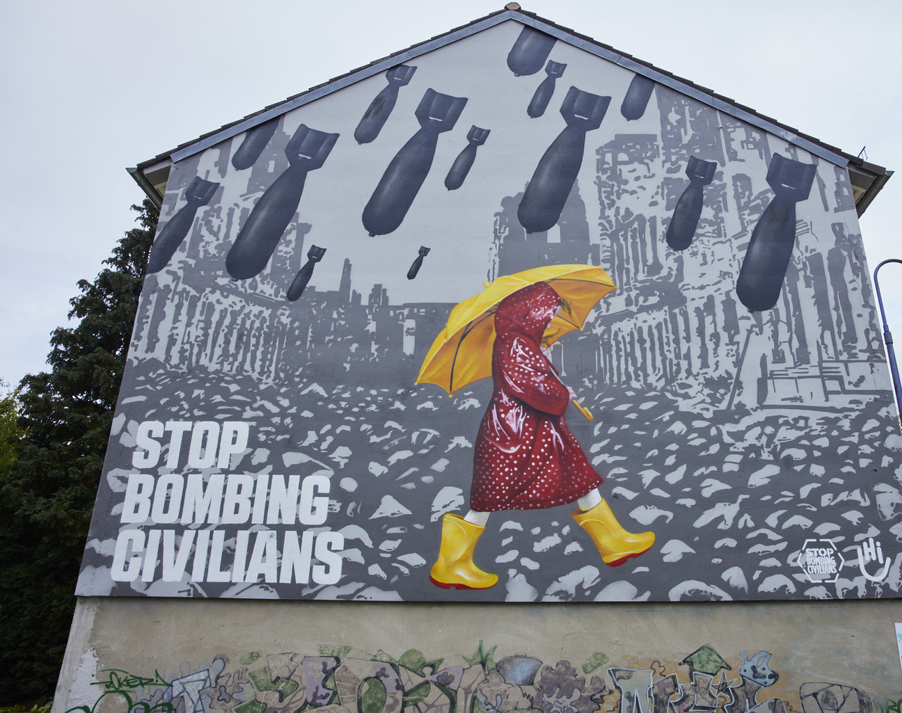 Eine Figur mit Regenklamotten und Regenschirm läuft unter einem bedrohlichen Bombenschauer